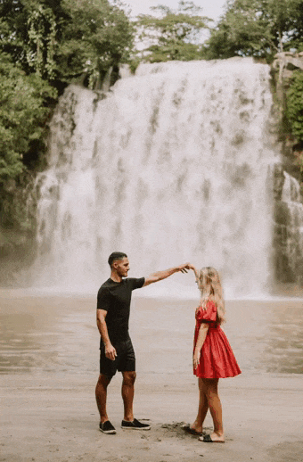 costa rica A couple enjoying a photo opportunity in front of a stunning waterfall captured by a talented Costa Rica photographer.