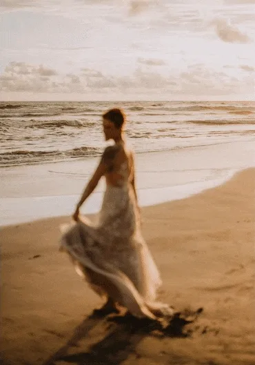 costa rica A wedding bride walking on the beach at sunset, captured beautifully by a Costa Rica photographer.