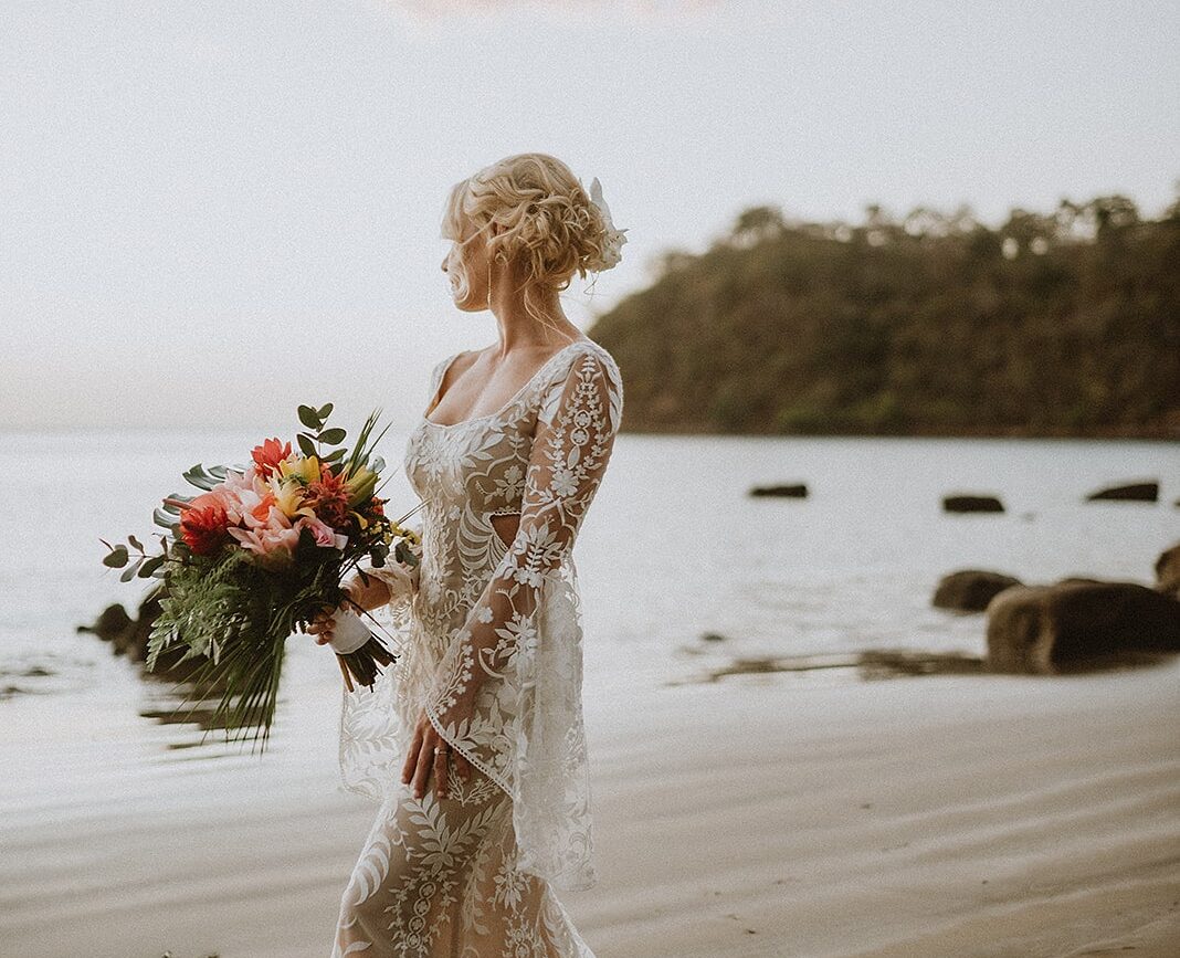 costa rica A wedding photo captures the beautiful moment as a bride walks down the beach, bouquet in hand.