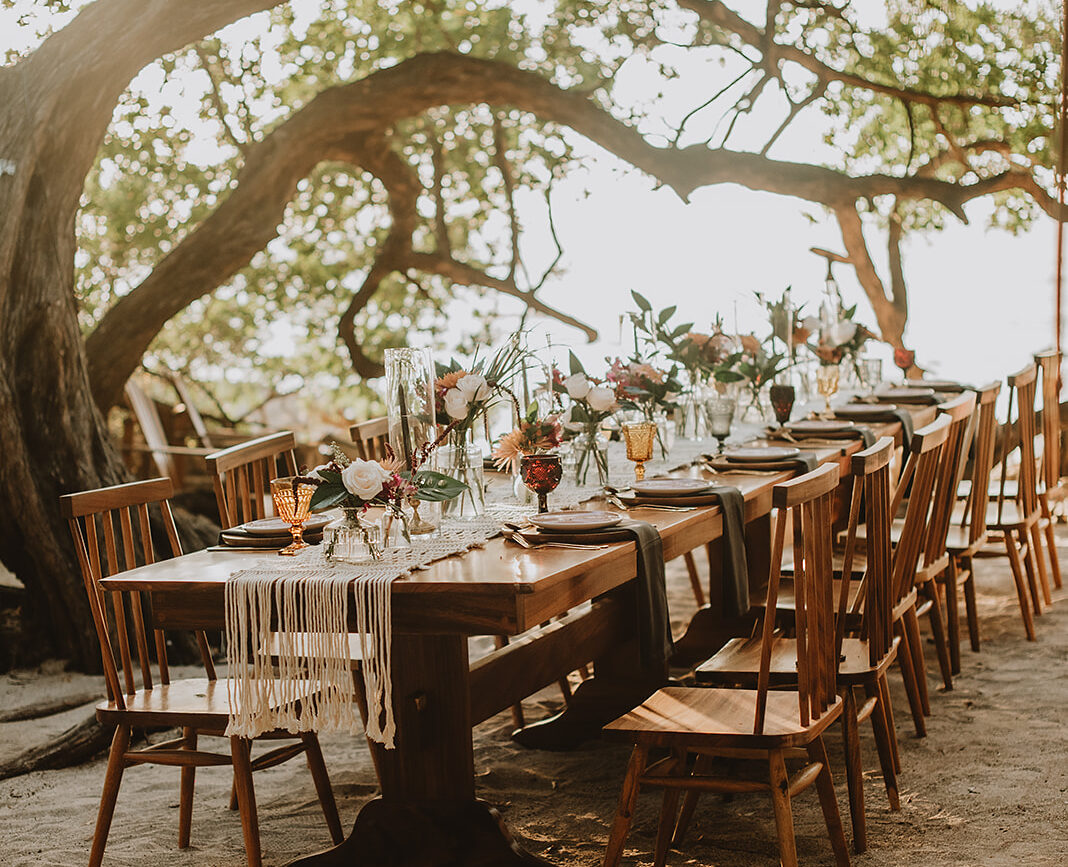 costa rica A beach table set under a tree with a mesmerizing playa backdrop for an unforgettable wedding captured beautifully by a talented Costa Rica photographer.