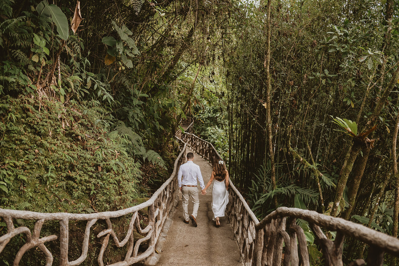 costa rica A couple walking down a wooden walkway in the jungle, captured in a photo.