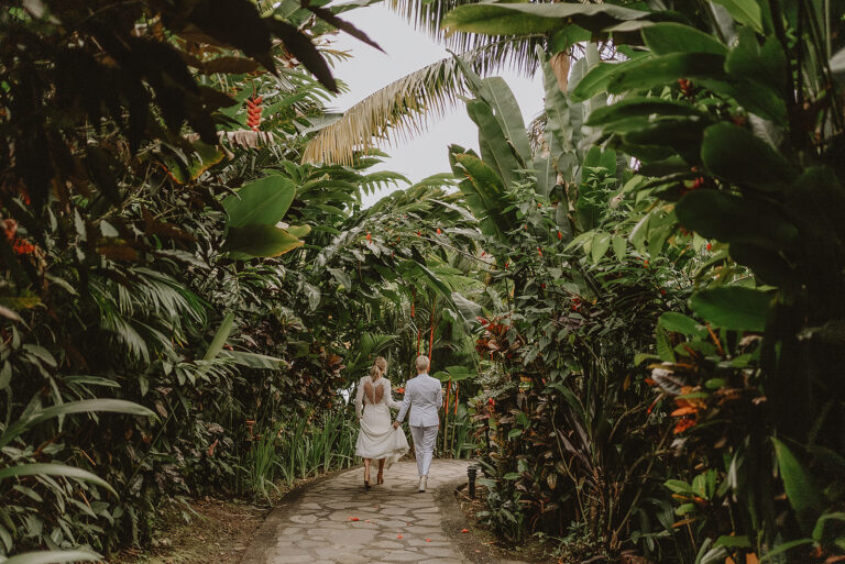 costa rica A bride and groom walking down a tropical jungle path, capturing a beautiful wedding photo on Playa Beach.