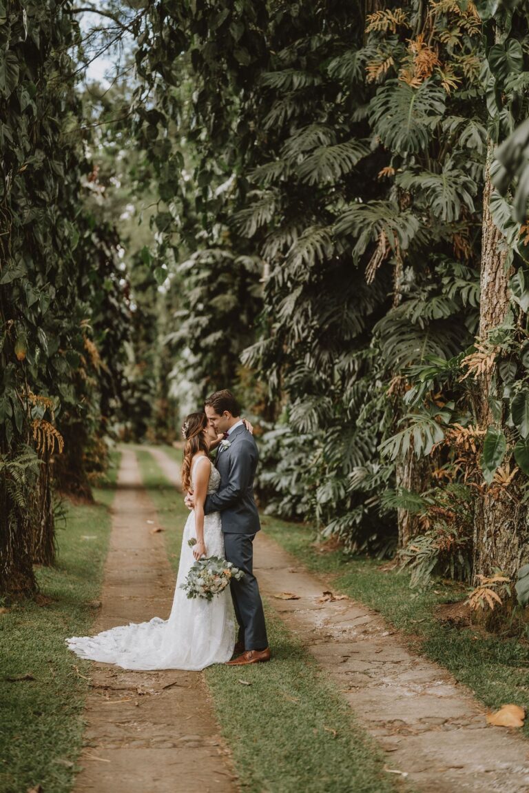 costa rica A wedding couple kissing in the middle of a lush garden captured by a talented Playa Costa Rica photographer.