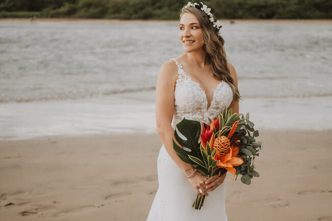 costa rica A bride holding her bouquet on the beach, captured in a beautiful wedding photo.