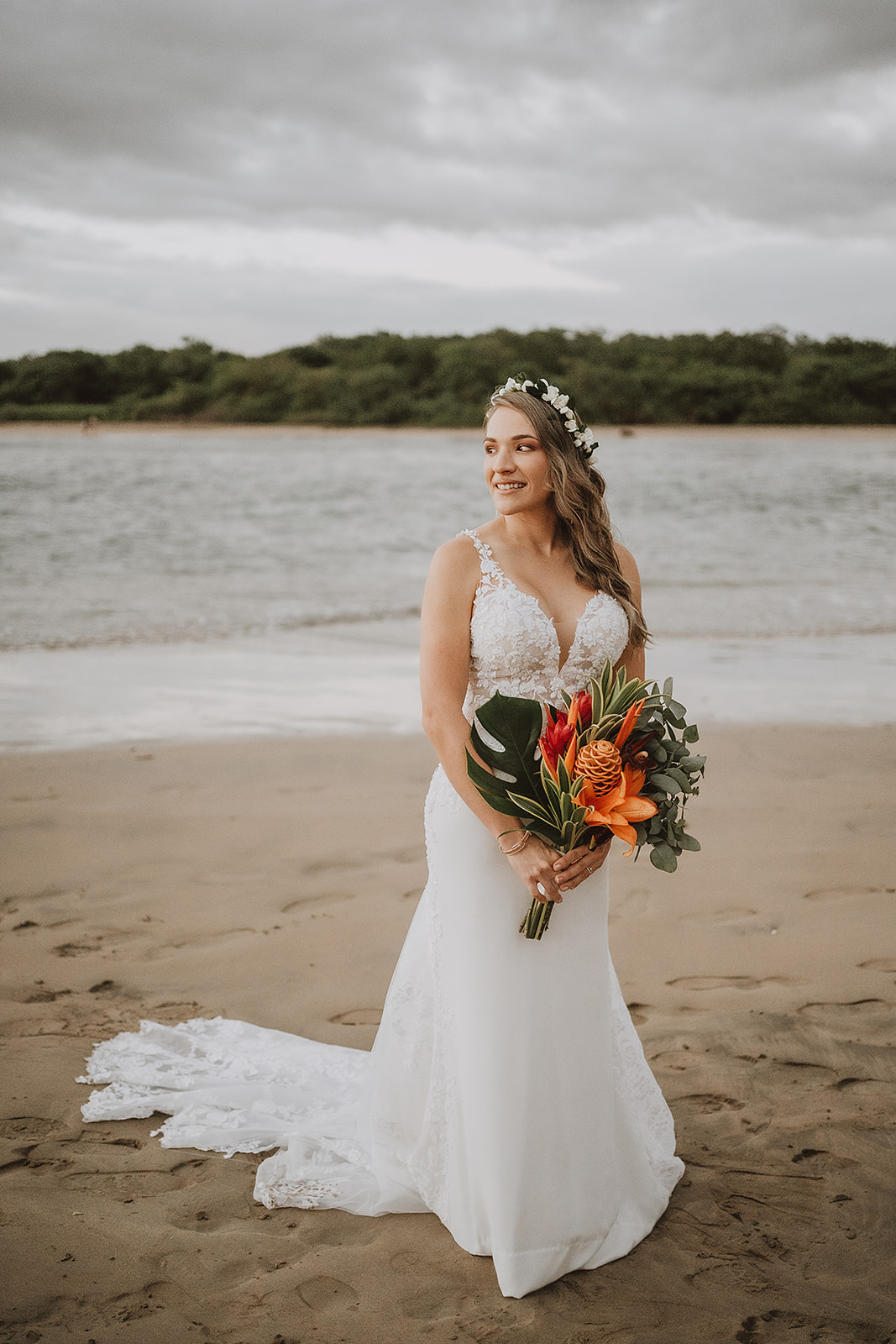 costa rica A bride holding her bouquet on the beach, captured in a beautiful wedding photo.