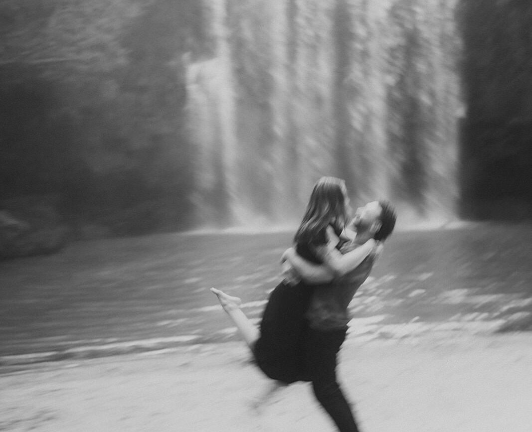 costa rica A black and white photo of a couple in front of a Top Waterfall.