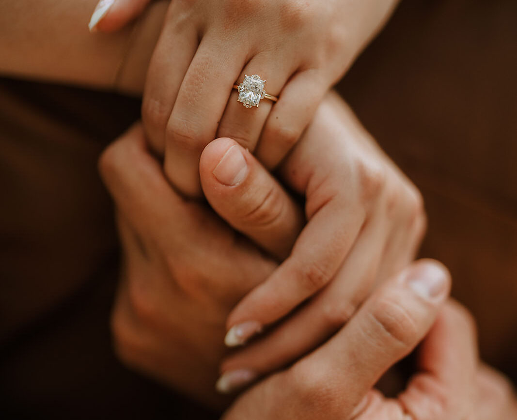 costa rica A close up of hands holding an engagement ring while standing near a stunning waterfall in Costa Rica.