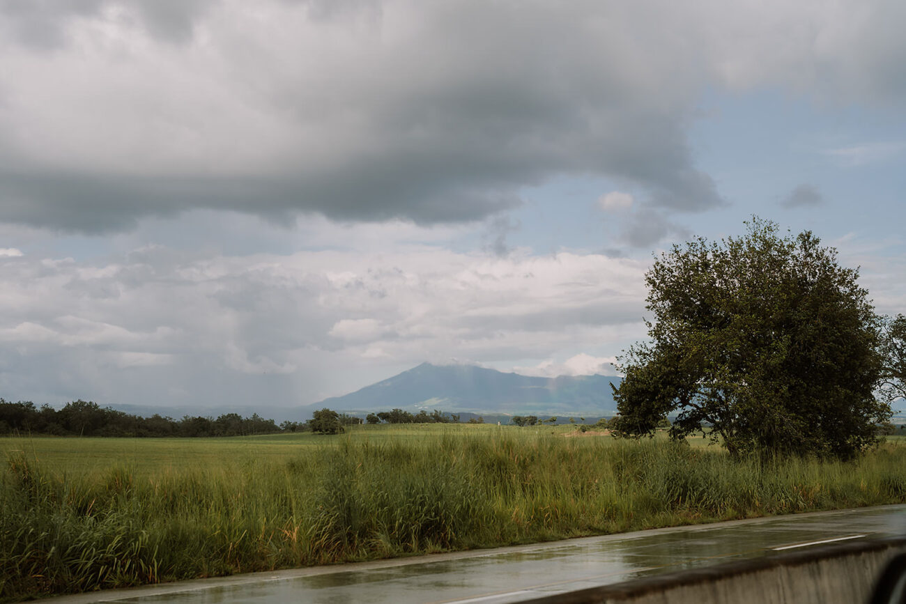 costa rica A car driving down a road with a mountain in the background, captured by a Costa Rica engagement photographer.