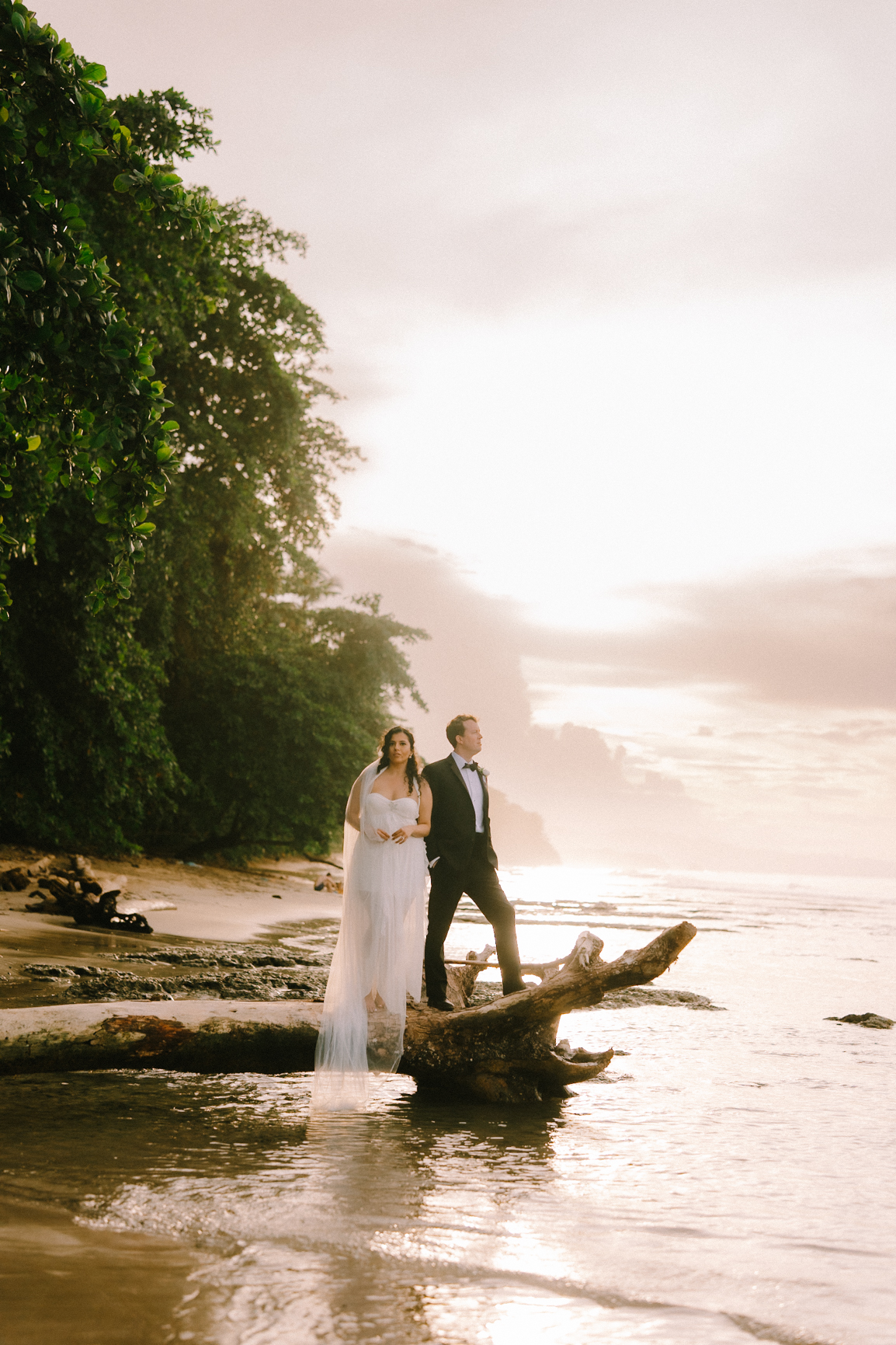 Costa Rica Wdding Couple on a log by the sea in Puerto Viejo