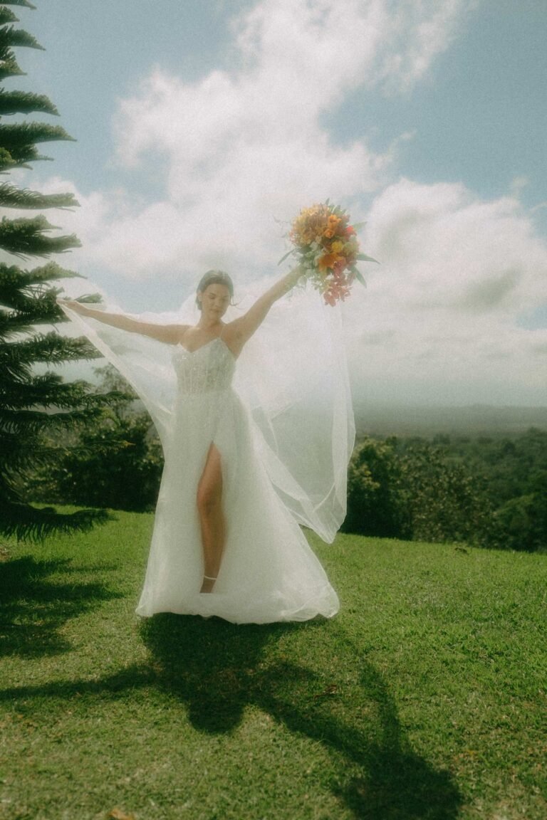 Best Documentary Wedding Photographers In Costa Rica | Adri and Lucas 20 Bride raising her bouquet on a green hilltop in Costa Rica