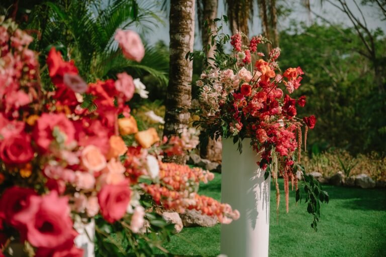 Best Documentary Wedding Photographers In Costa Rica | Adri and Lucas 16 Tropical wedding florals in coral and pink beside a palm tree in Costa Rica
