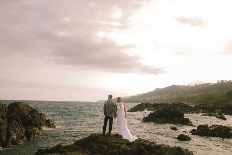 Best Documentary Wedding Photographers In Costa Rica | Adri and Lucas 15 Bride and groom on a rocky Costa Rica coastline at sunset