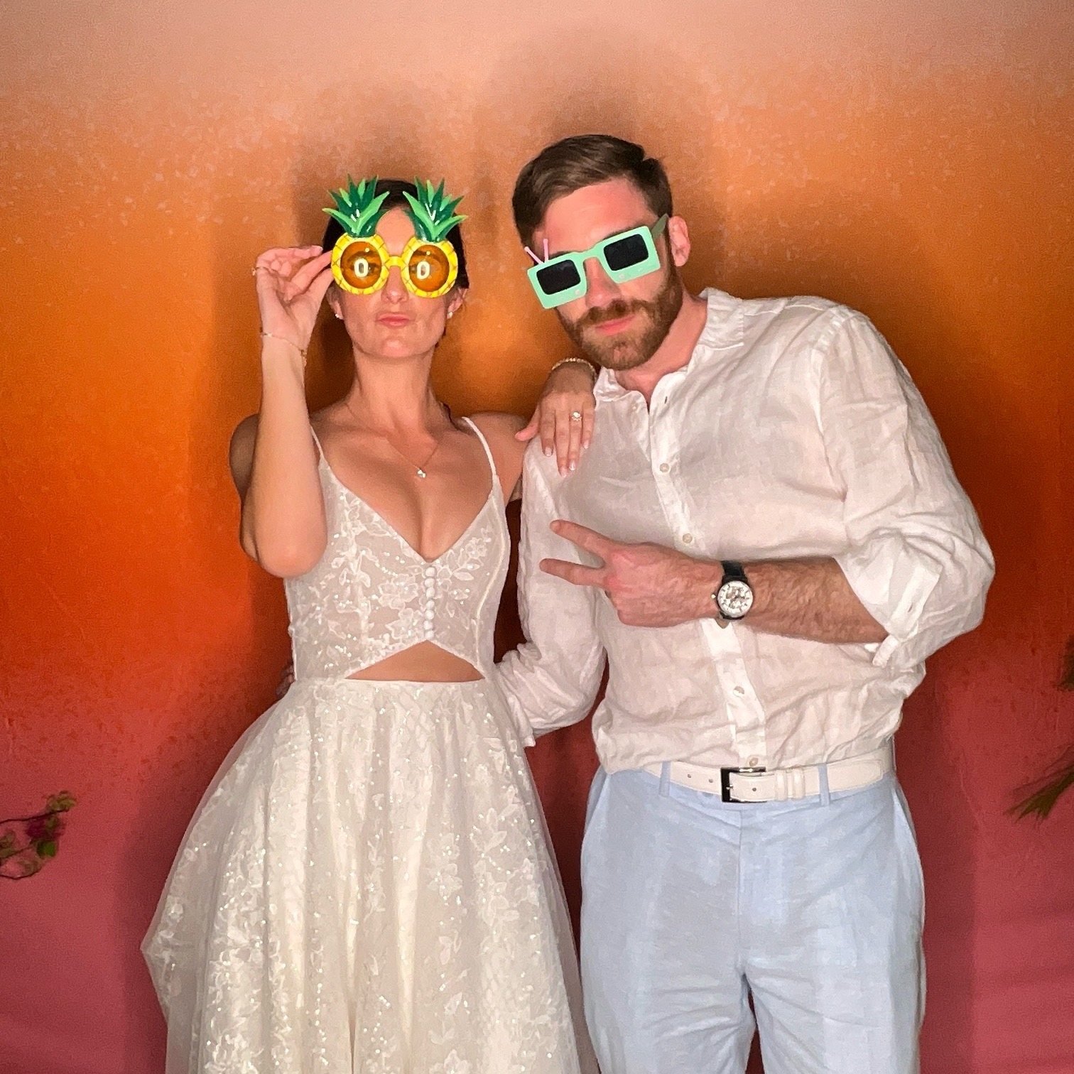 Couple posing in front of the photobooth backdrop