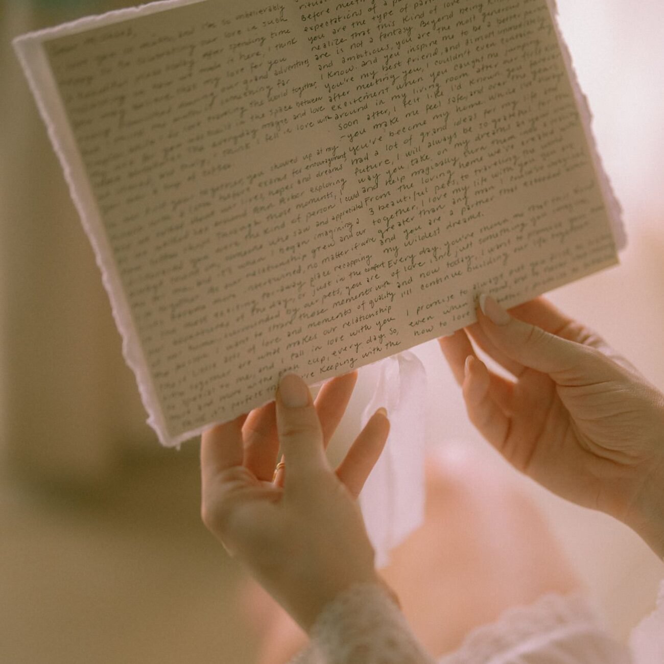 Hands holding open a handwritten page
