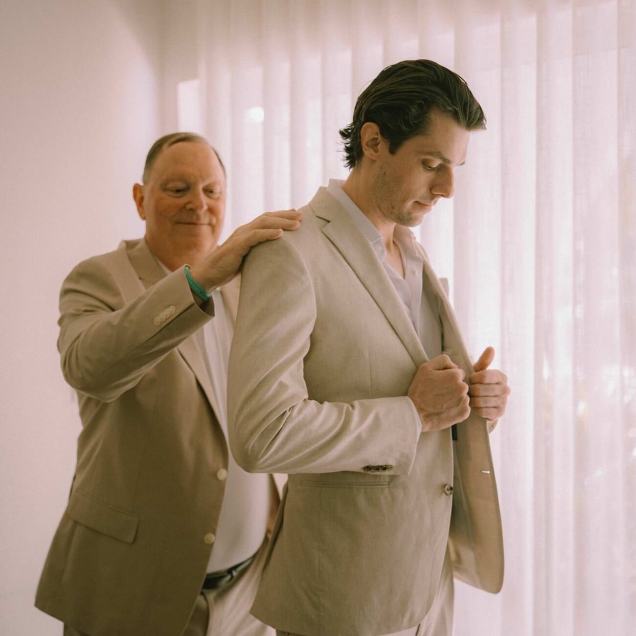 A guest helping the groom with his jacket before the ceremony