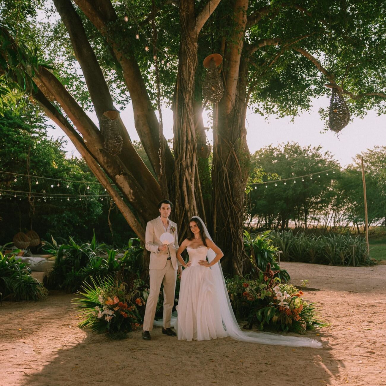 Wide view of the couple under a large tree at Pangas Beach Club in Tamarindo